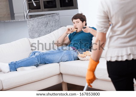 Lazy man on a couch doesn\'t want to help his wife