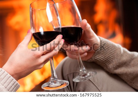 A closeup of cheering with glasses of red wine