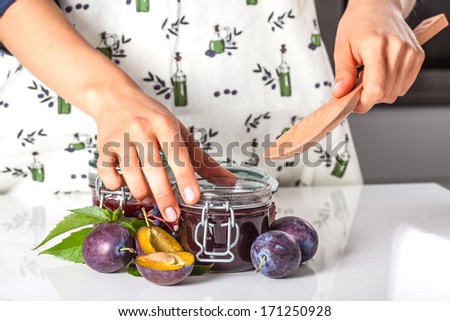 Filling the jar with a homemade plum jam