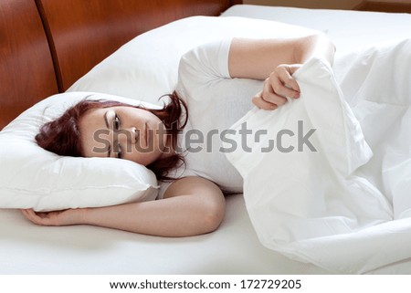 Unhappy tired woman getting up at the morning