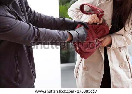 A woman trying not to let a man take her bag
