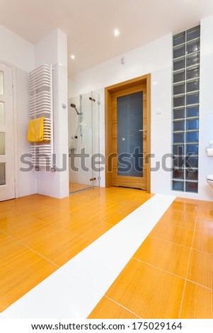 Big orange bathroom with white heater and wooden door