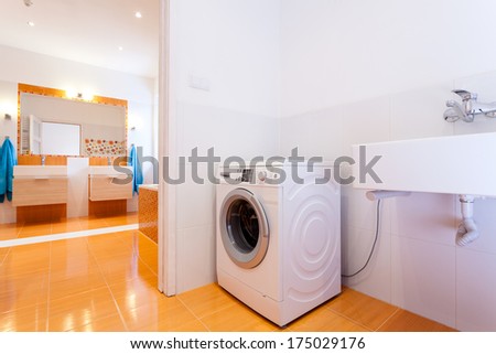 Big comfortable practical bathroom with washing machine at big house