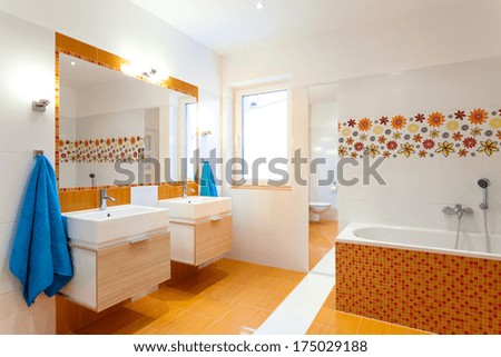 Modern orange bathroom with two sinks for big family
