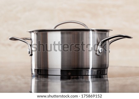 One new modern metal pot on clean shiny kitchen top