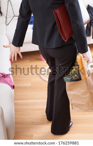 A woman irritated by mess after having come home from work wand shopping