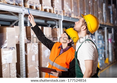 Warehouse engineer ordering to worker how to work