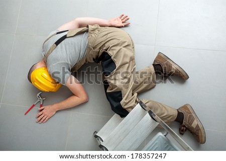 Handyman lying unconscious on the floor near the ladder
