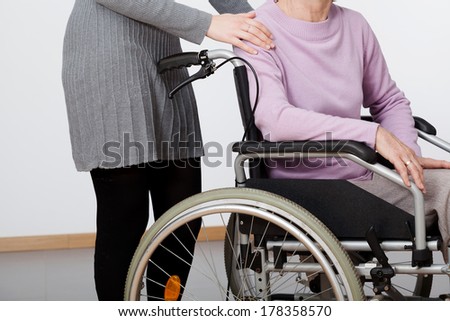Daughter supporting her elder mom on wheelchair