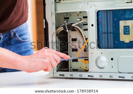 Computer specialist use screwdriver to repair hardware