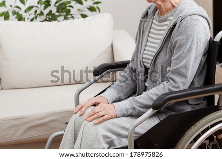 Lady sitting calm on wheelchair in her house