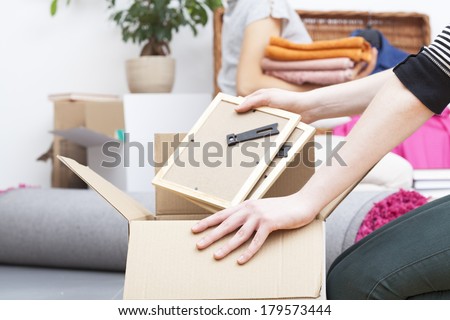 Close up of woman\'s hand packing two photo frames