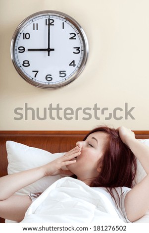 Waking up and yawning woman in bedroom