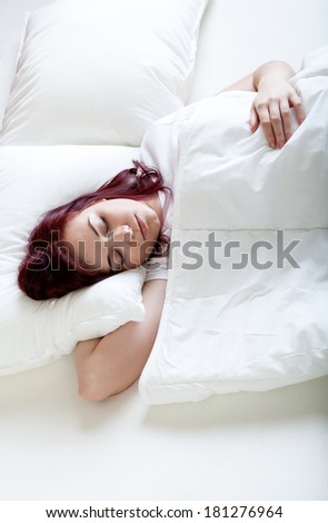 Lady sleeping comfortable in her bright bed