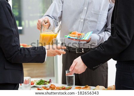 Manager with jug of orange juice and sandwiches