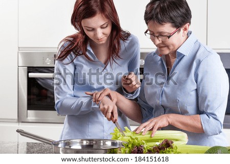 Mother and daughter during cooking in kitchen