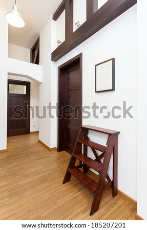 Vertical view of a corridor with brown decorative ladder