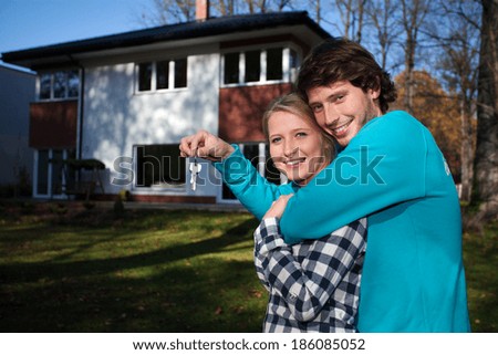 Happy couple in front of the new house
