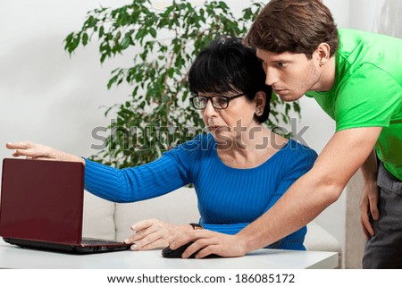 Elderly woman learning computer science with boy