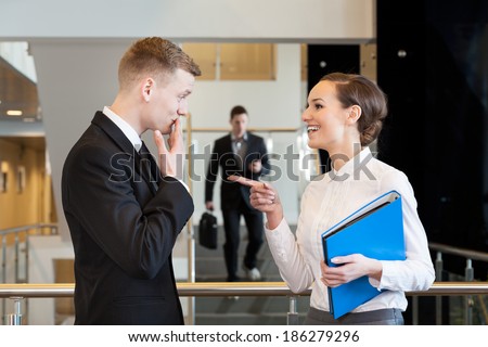 Two office workers flirting at the office centre