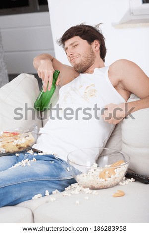 Lazy man sitting on couch and watching tv