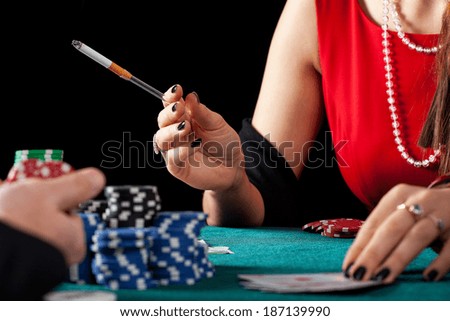 A closeup of a female casino gambles smoking a cigarette