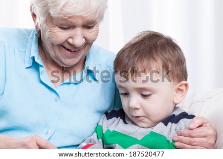 Smiling grandma playing with her little grandson