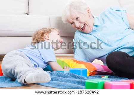 Grandmother cheerfully playing with her grandson indoors