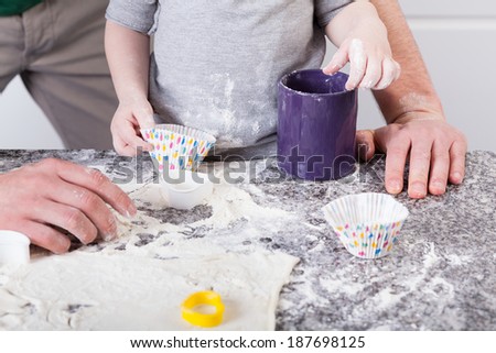 Dad and son baking sweet cookies in kitchen