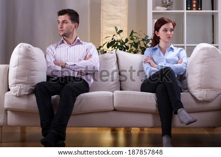 Young couple sitting on the sofa after quarrel