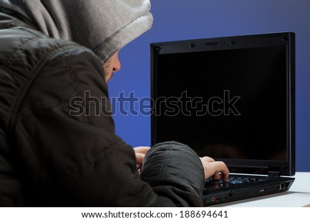 Hacker trying to break a secret code on a laptop