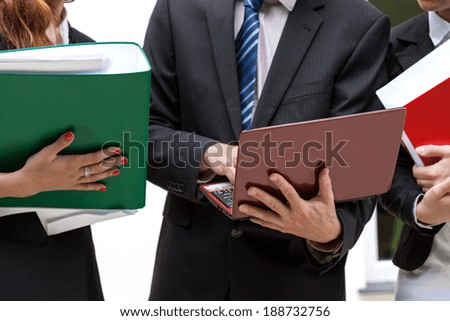 Office workers holding file binders and netbooks