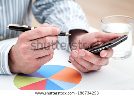 A colourful pie chart and a man working on his smartphone