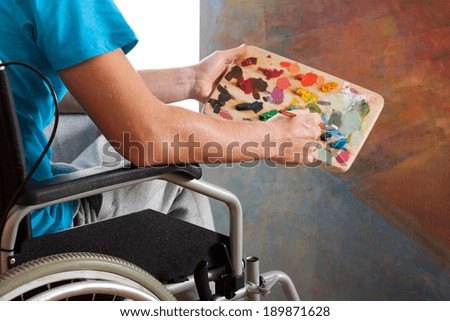 Disabled young painter with palette in hand