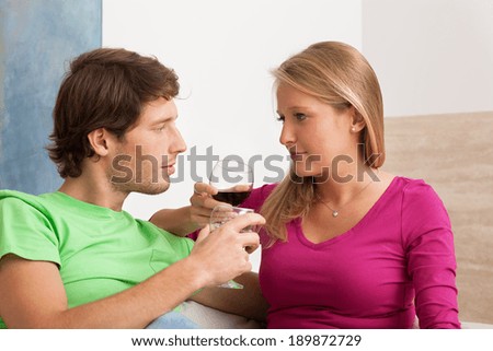 Young couple drinking red wine in the living room