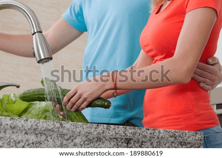Vegan couple washing the vegetables for dinner
