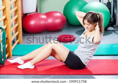 Young girl doing crunches on gym mat