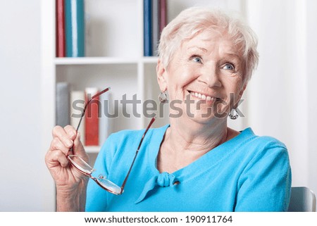 Portrait of elderly woman smiling with glasses in hand