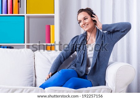 Woman learning foreign language in her home by using mp3 player