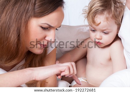 A concerned mom touching her son\'s delicate body