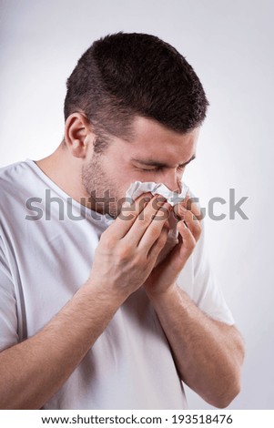 Sick young man with running nose, vertical