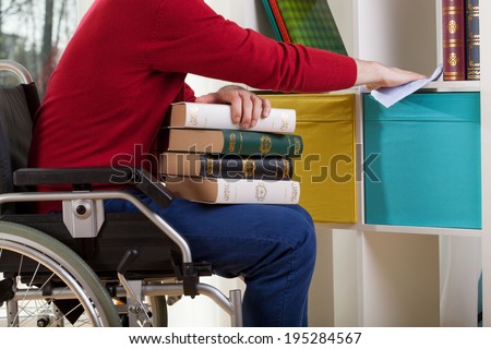 Disabled man on wheelchair during cleaning furniture