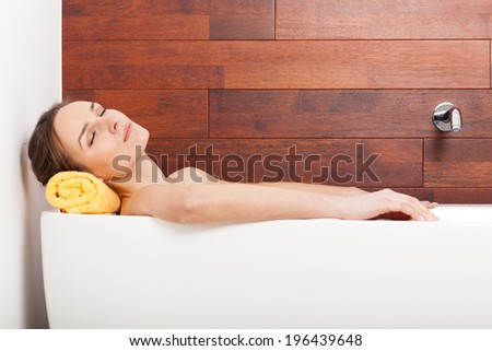 Pretty woman lying in white bath and relaxing