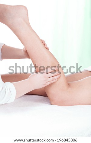 Woman during leg massage in spa, vertical