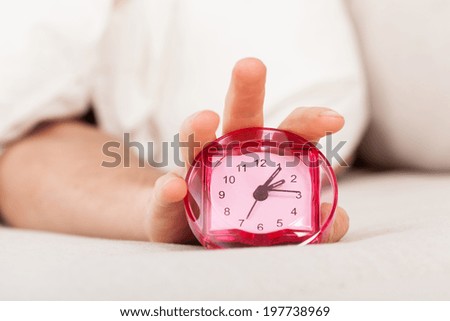 A pink plastic alarm clock of a lazy person