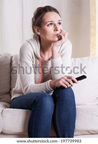 Young woman scared while watching movie at home