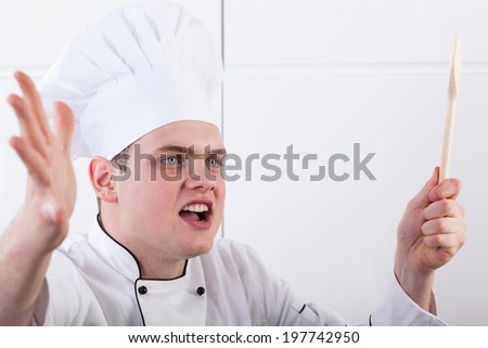 A closeup of an angry chef shouting on his workers