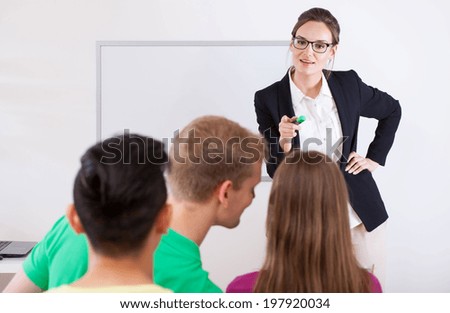 Young teacher pointing on a talking student