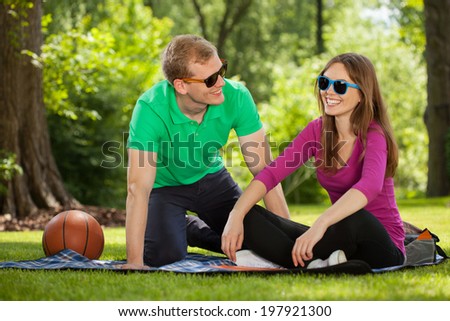 Young couple sitting on a blanket in the park