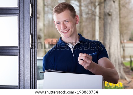 A smiling man accepting a package by signing it